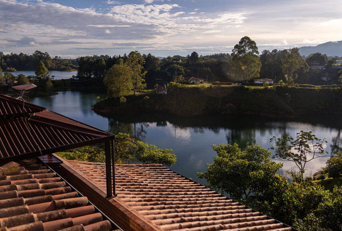 Breathtaking view of Finca Conejo Blanco with lake and lush greenery, perfect for eco-friendly retreats.