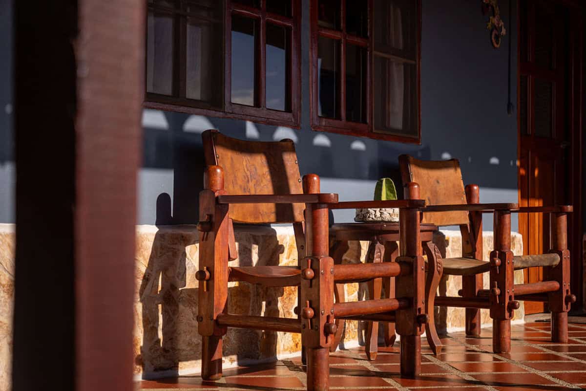 Rustic wooden chairs on the porch of Finca Conejo Blanco, a charming countryside estate.