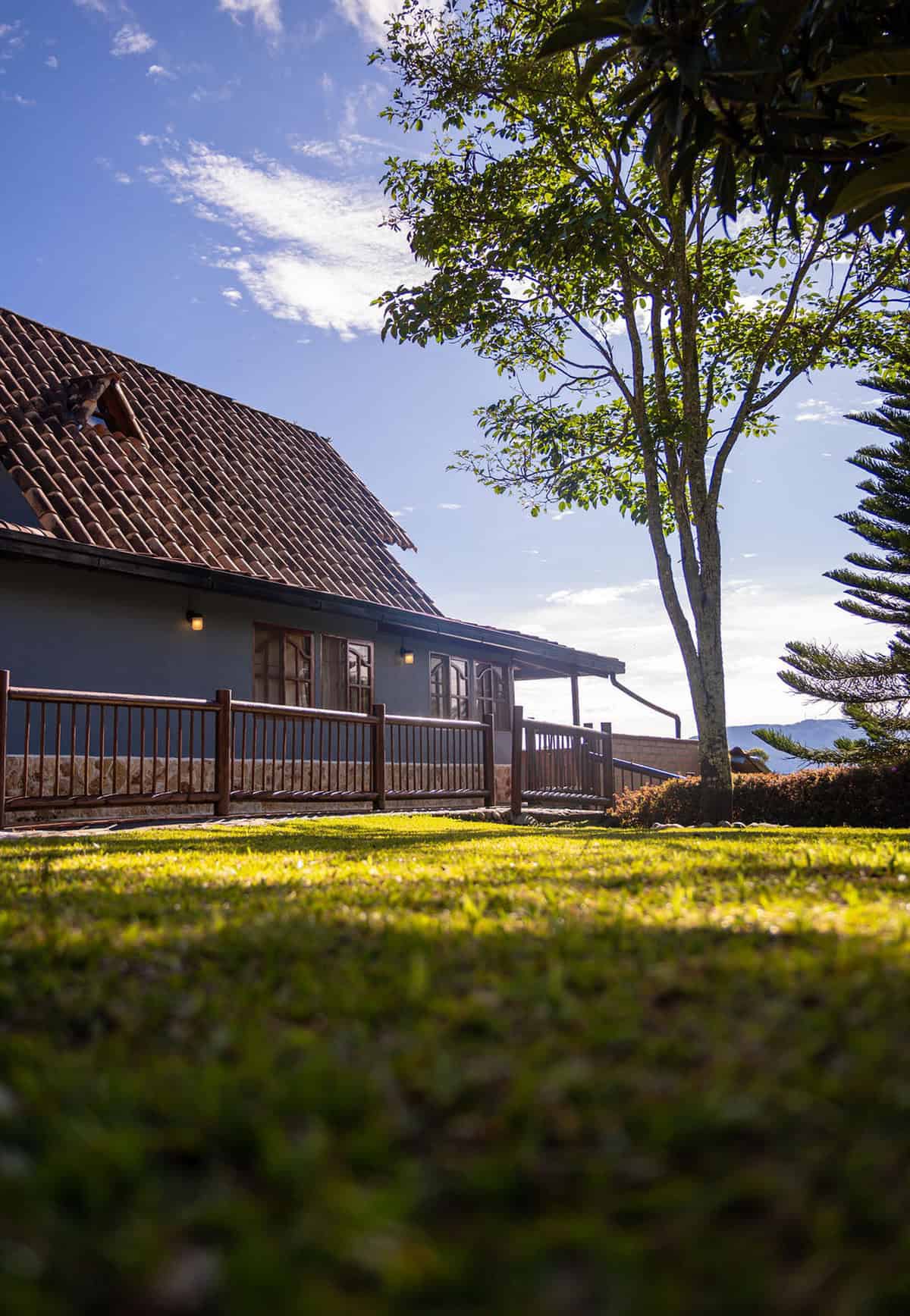 Cozy countryside house with terracotta roof and lush green garden at Finca Conejo Blanco, ideal for rural retreats.