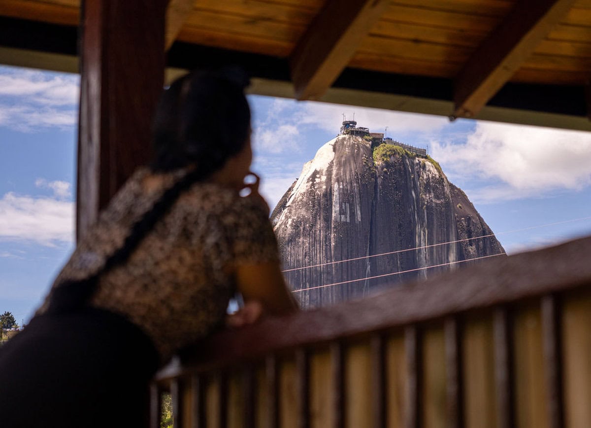 Majestic view of Sugarloaf Mountain from Finca Conejo Blanco viewing deck, with a woman enjoying the scenery.