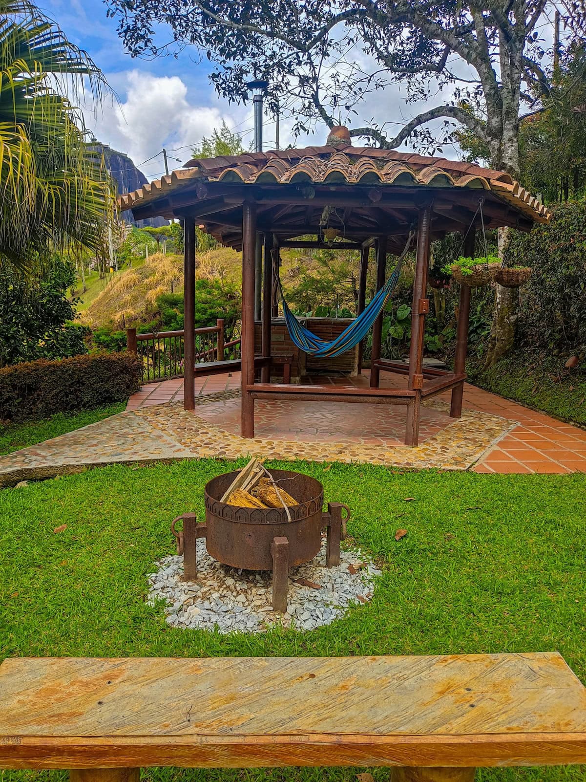 Fire pit and wooden gazebo with lush garden