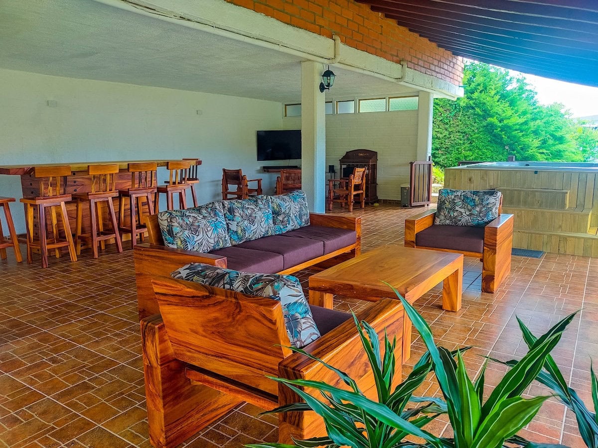 Rustic indoor lounge area at CMS Finca Conejo Blanco with wooden furniture and communal space.