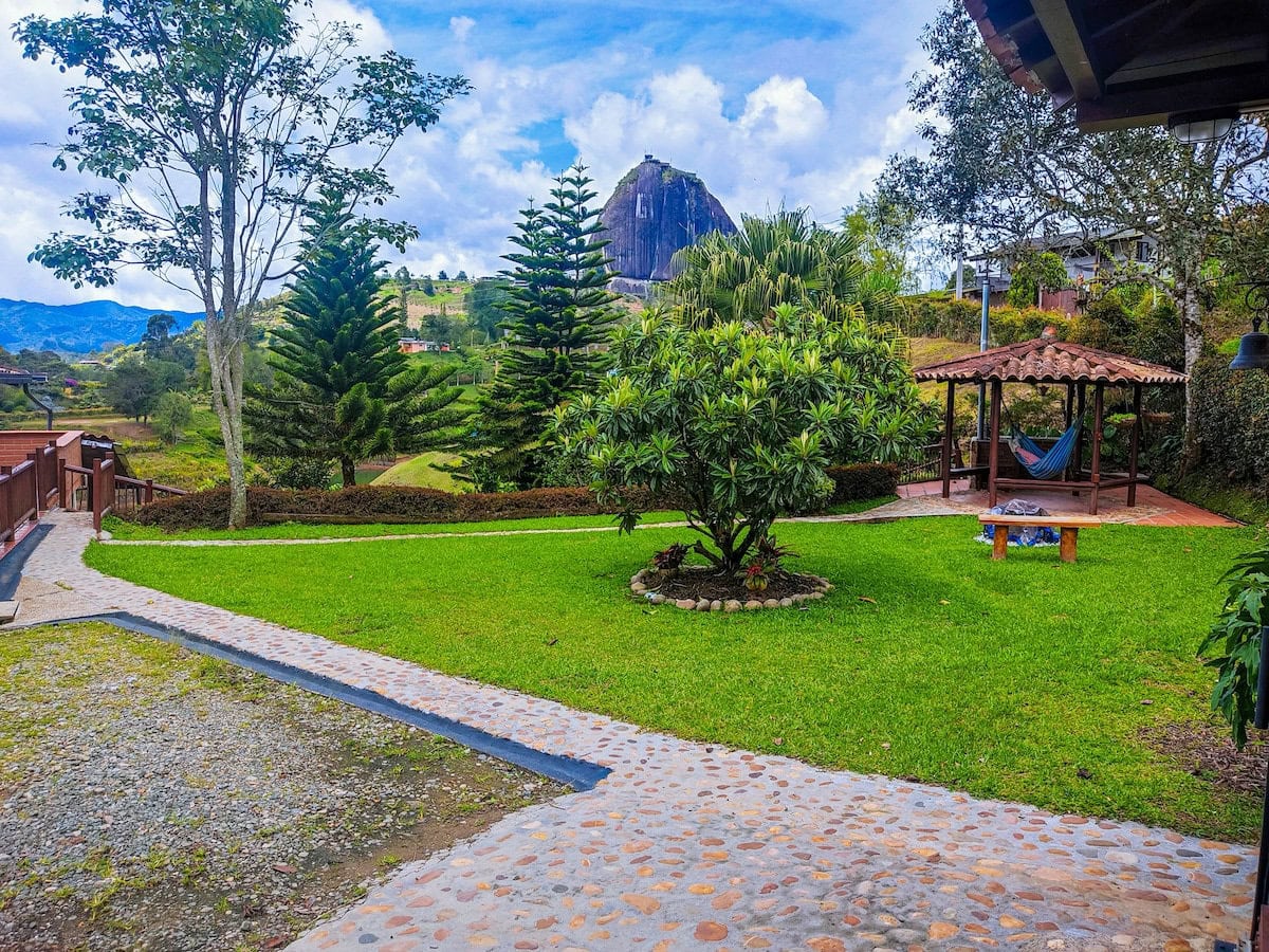 Lush garden view at CMS Finca Conejo Blanco with vibrant greenery and mountain backdrop.